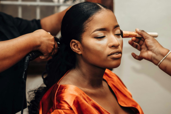 A photo of a lady having her makeup done by a mobile makeup artist.